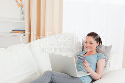 Beautiful female making an online payment with her credit card w