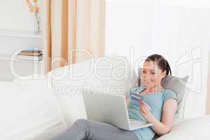 Beautiful female making an online payment with her credit card w