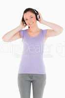 Good looking woman posing with headphones while standing