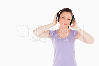 Charming woman posing with headphones while standing