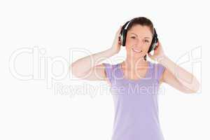 Charming woman posing with headphones while standing