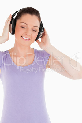 Good looking female posing with headphones while standing