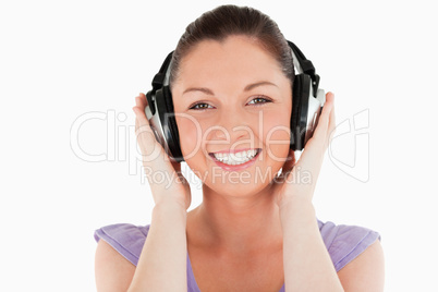 Portrait of a good looking woman posing with headphones while st