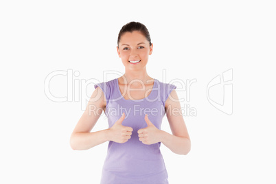 Good looking woman posing with her thumbs while standing