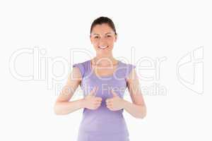 Good looking woman posing with her thumbs while standing