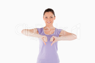 Beautiful woman posing with her thumbs down while standing