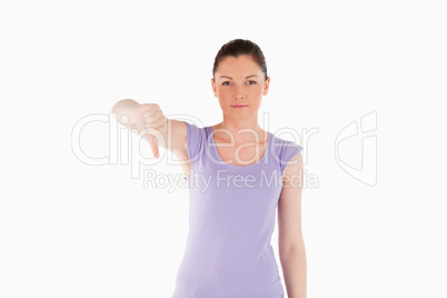 Beautiful woman pointing her thumb down while standing