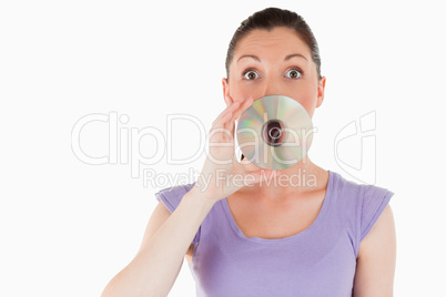 Good looking woman hiding her mouth with a CD