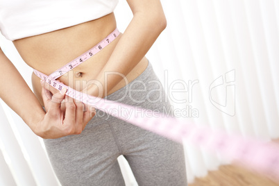 Young Slim Woman Measuring Waist With Tape Measure