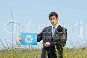 Green energy young businessman hold recycling sign