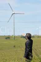 Green energy - Young businessman point windmill