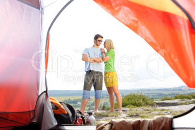 Camping young couple outside tent panoramic view