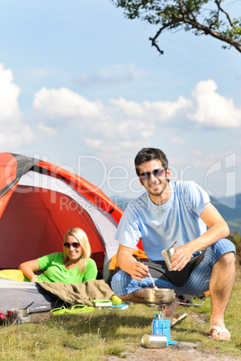 Camping young couple with tent cook countryside