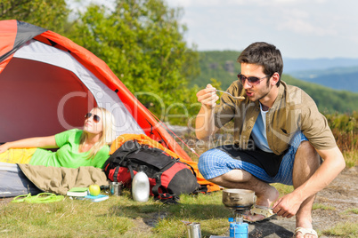 Camping young couple with tent cook countryside