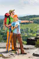 Hiking young couple point at panoramic view