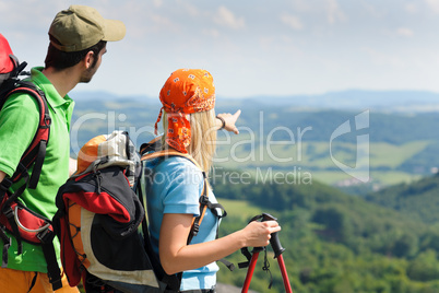 Hiking young couple point at panoramic view