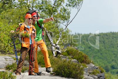 Hiking young couple point at panoramic view