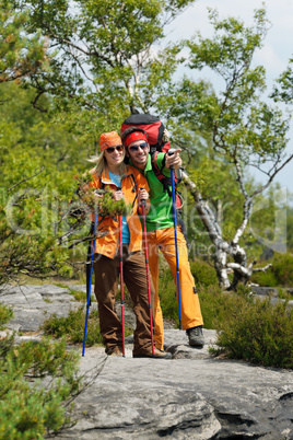 Hiking young couple point at panoramic view