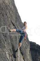 Rock climbing fit man on rope sunny