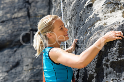 Rock climbing blond woman on rope