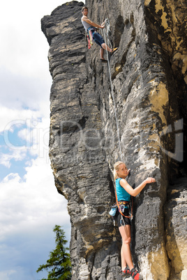 Rock climbing male instructor woman hang rope