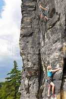 Rock climbing male instructor woman hang rope