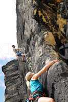 Rock climbing male instructor woman hang rope