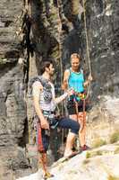 Rock climbing young man showing woman rope