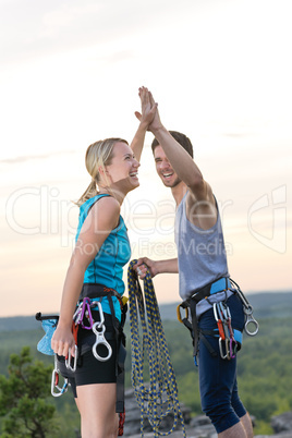 Rock climbing cheerful alpiners on top sunset