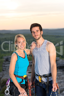 Rock climbing active couple on top sunset