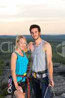 Rock climbing active couple on top sunset