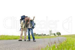 Hiking young couple backpack asphalt road countryside