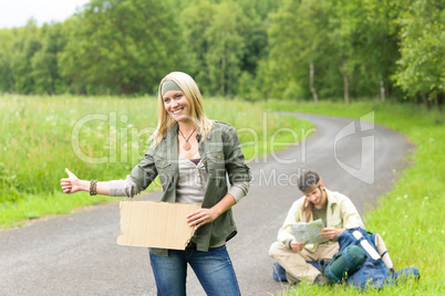 Hitch-hiking young couple backpack asphalt road