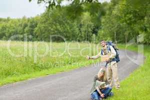 Hitch-hiking young couple backpack asphalt road