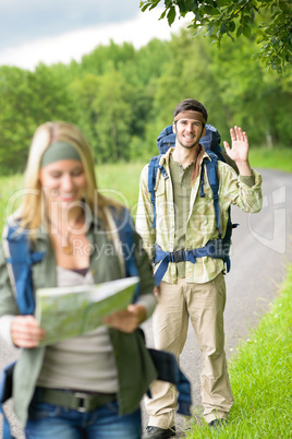 Hiking young couple backpack asphalt road countryside