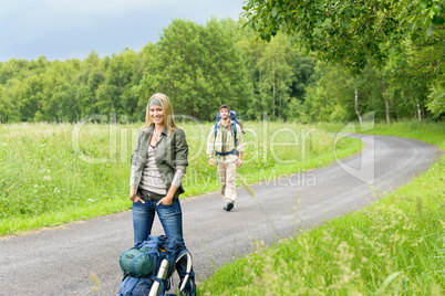 Hiking young couple backpack asphalt road countryside