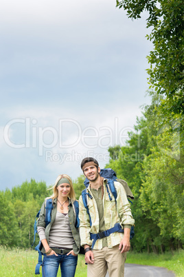 Hiking young couple backpack asphalt road countryside