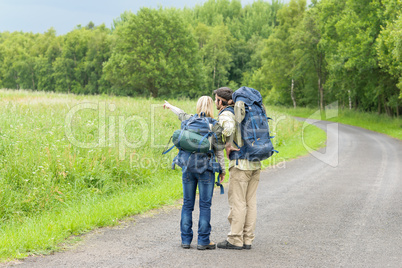 Hiking young couple backpack asphalt road countryside