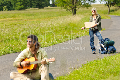 Hitch-hiking young couple backpack asphalt road