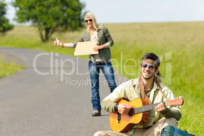 Hitch-hiking young couple backpack asphalt road