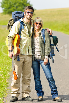 Hiking young couple backpack tramping asphalt road