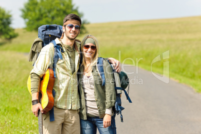 Hiking young couple backpack tramping asphalt road