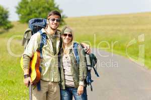 Hiking young couple backpack tramping asphalt road