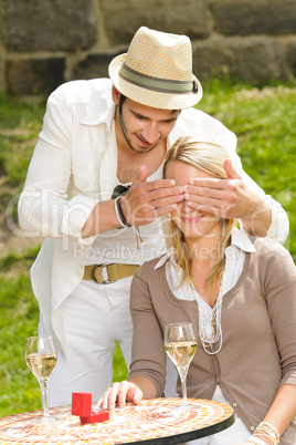 Surprised woman receiving wedding ring sunny terrace