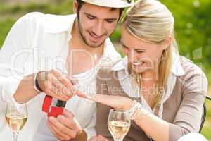 Cheerful woman receiving wedding ring sunny terrace