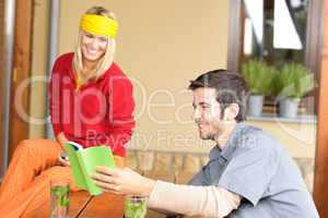 Tramping young couple relax looking in book