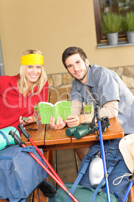 Tramping young couple relax looking in book