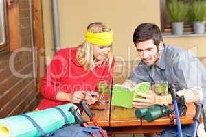 Tramping young couple relax looking in book
