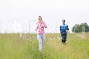 Jogging sportive young couple running meadow field