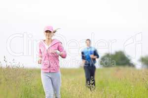 Jogging sportive young couple running meadow field